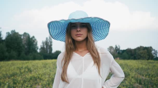 Schönheit lächelndes Mädchen auf dem Frühlingsfeld. Wiese. Porträt einer lachenden und glücklichen jungen Model-Frau mit gesunden langen Haaren, die die Natur genießt. schöne junge Frau im Freien — Stockvideo