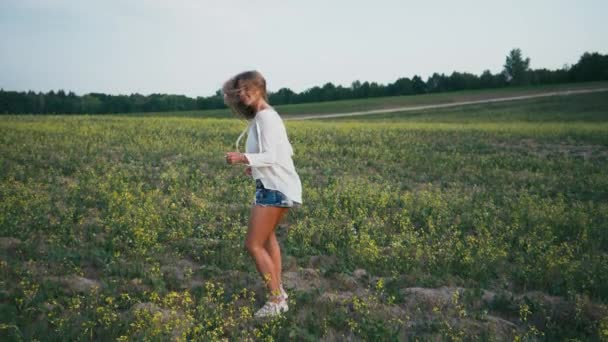 Krása, usmívající se dívka na jaře pole. Louku. Portrét se smíchem a šťastný mladý model ženy s zdravé vlasy dlouho foukání Užíváme si přírody. Krásná mladá žena venku — Stock video