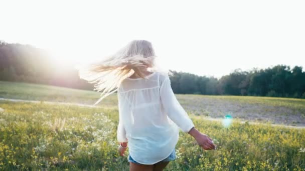 Schönheit lächelndes Mädchen auf dem Frühlingsfeld. Wiese. Porträt einer lachenden und glücklichen jungen Model-Frau mit gesunden langen Haaren, die die Natur genießt. schöne junge Frau im Freien — Stockvideo