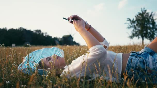 Kvinna i parken sommaren med mobiltelefon. Autentiska kreativa skott — Stockvideo