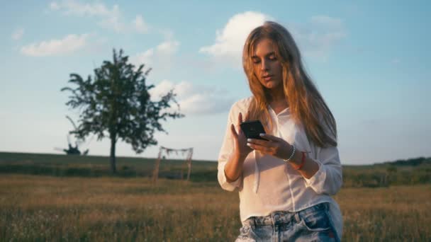 Γυναίκα στο πάρκο καλοκαίρι χρησιμοποιώντας το κινητό τηλέφωνο. Αυθεντική δημιουργική Shot — Αρχείο Βίντεο