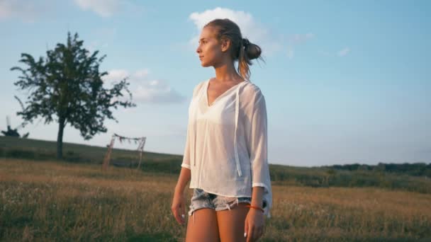 Menina sorrindo beleza no campo de primavera. Meadow. Retrato de Rindo e feliz jovem modelo mulher com cabelos longos e saudáveis soprando Apreciando a natureza. bela jovem mulher ao ar livre — Vídeo de Stock