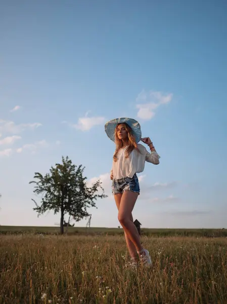 Bahar alan kız gülümseyen güzellik. Çayır. Sağlıklı uzun üfleme saç Enjoying doğa ile gülüyor ve mutlu genç model kadın portresi. Güzel genç kadın açık havada