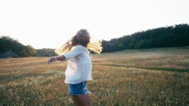 Bahar alan kız gülümseyen güzellik. Çayır. Sağlıklı uzun üfleme saç Enjoying doğa ile gülüyor ve mutlu genç model kadın portresi. Güzel genç kadın açık havada