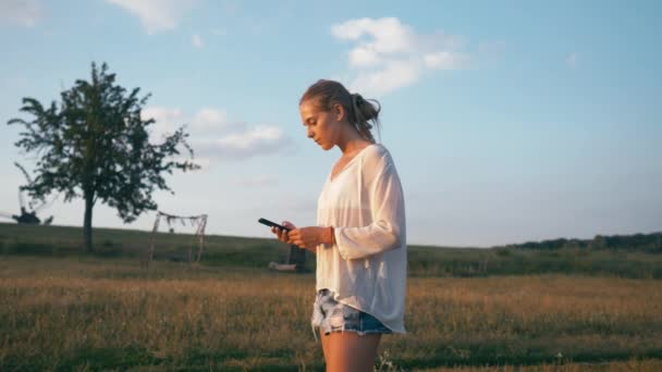 Γυναίκα στο πάρκο καλοκαίρι χρησιμοποιώντας το κινητό τηλέφωνο. Αυθεντική δημιουργική Shot — Αρχείο Βίντεο
