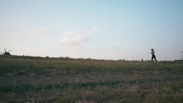 Mujer corredora corriendo en el parque haciendo ejercicio al aire libre rastreador de fitness tecnología usable. Correr al atardecer — Vídeo de stock