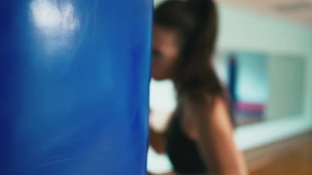 Bella gara mista Kickboxing donna allenamento sacco da boxe in palestra feroce forza in forma corpo kickboxer serie — Video Stock