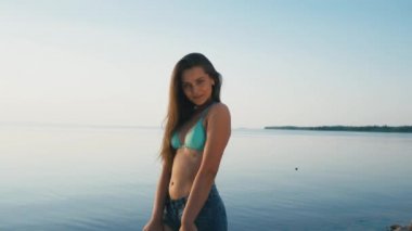 Güzel genç kadın gülümseyen saç tropik sahilde rüzgarda üfleme portresi kapatın