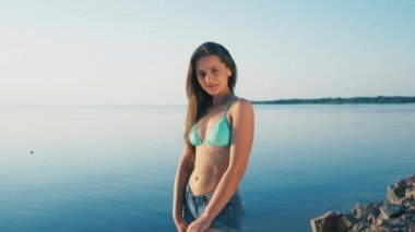 Mutlu genç kadın Plajı'nda. Kız turistik tatil el barış işareti kamera üzerinde bikini giyiyor