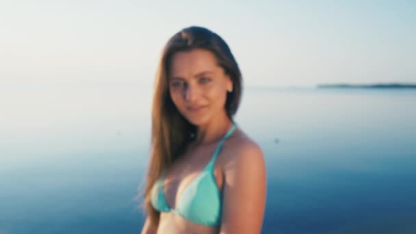 Happy young woman at beach. Girl tourist is wearing bikini on vacation gesturing peace sign at camera — Stock Video