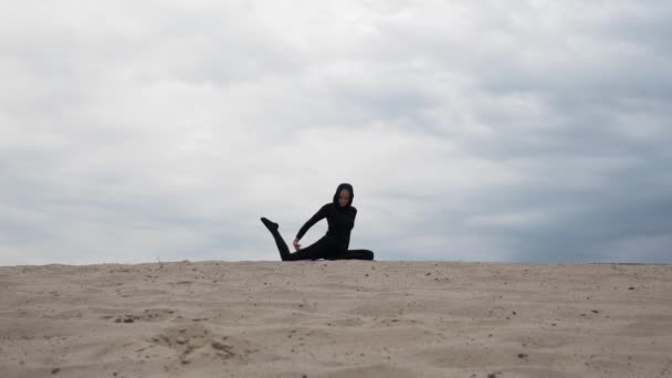 Muslimische Frau im Hijab beim Yoga in der Wüste bei Sonnenuntergang — Stockvideo