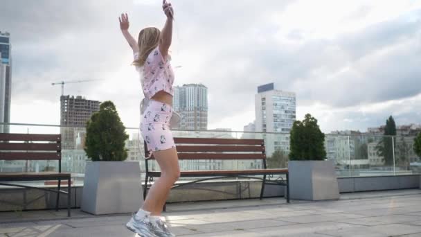 Feliz linda chica hipster milenial divertirse al aire libre en las calles de la ciudad fondo urbano. Mujer bella girando, saltando y riendo. Libertad. Movimiento lento — Vídeos de Stock