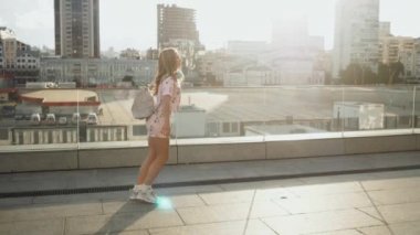 Kentsel şehir sokaklarında çalışan ve gün batımı arka plan, hayattan zevk mutlu neşeli kadın Titus