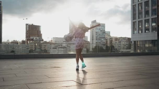 Gelukkig schattig millenial hipster meisje plezier buiten bij stad straten stedelijke achtergrond. Schoonheid vrouw spinnen, springen en lachen. Vrijheid. Slow motion — Stockvideo