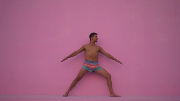 Razza mista ispanico giovane uomo con torso nudo praticare esercizio di fitness yoga su sfondo rosa. Sport, meditazione e stile di vita. Meditazione pacifica per una buona salute — Video Stock