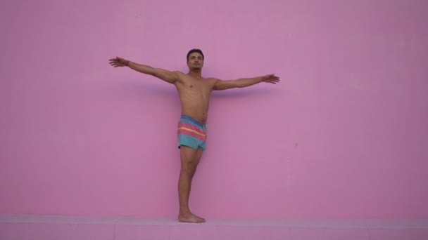 Joven hispano de raza mixta con torso desnudo practicando ejercicio físico de yoga sobre fondo rosa. Concepto de deporte, meditación y estilo de vida. Meditación pacífica para una buena salud — Vídeo de stock