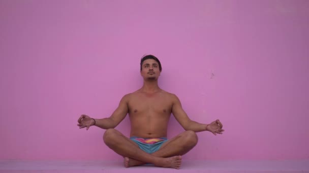 Razza mista ispanico giovane uomo con torso nudo praticare esercizio di fitness yoga su sfondo rosa. Sport, meditazione e stile di vita. Meditazione pacifica per una buona salute — Video Stock