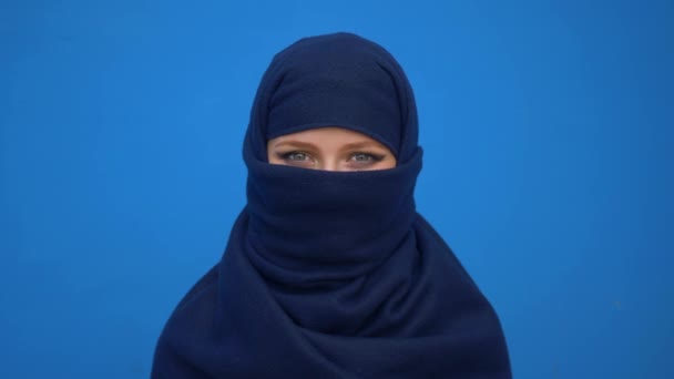 Primer plano retrato de encantadora joven musulmana mujer de negocios con hijab pañuelo en la cabeza buscando confiado sonriente profesional tranquilo ambicioso sobre fondo azul — Vídeos de Stock