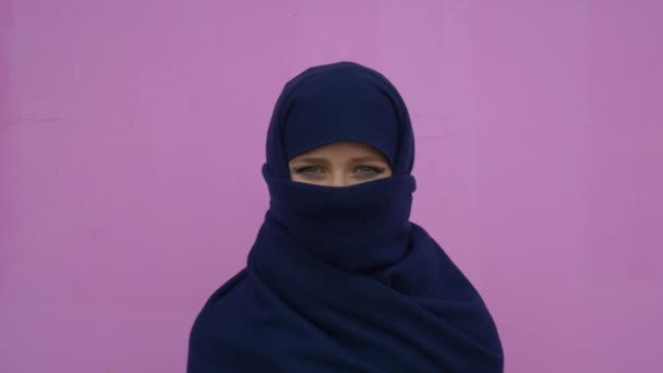 Emin gülümseyen sakin profesyonel iddialı pembe arka plan üzerinde seyir türban başörtüsü giyen güzel genç Müslüman iş kadın portresi kapatın — Stok video