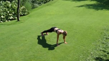 İnce bir rakam olan sarışın kadın Parkı nda jimnastik devreye girer. Bir çalışma yere fitness egzersiz yapıyor. Ağır çekim