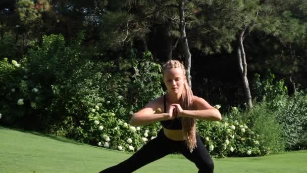 Mujer joven haciendo ejercicio, estiramiento y entrenamiento en cuclillas al aire libre. Saludable, fitness, estilo de vida de bienestar. Deporte, cardio, concepto de entrenamiento — Vídeos de Stock