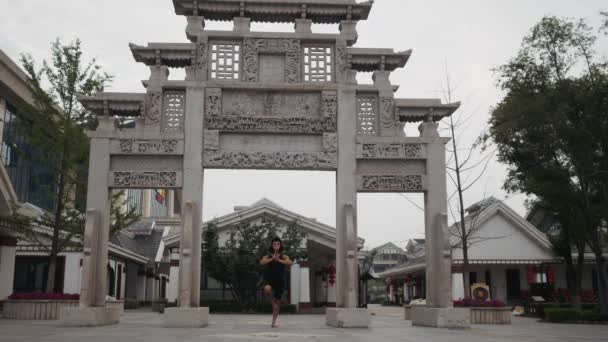 Hombre adulto actuando tonto divertido en la máscara de mono en frente del antiguo templo en algún lugar de Asia — Vídeo de stock