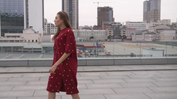빨간 드레스에 매력적인 여자가 도시에서 거리 — 비디오