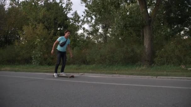 混合的种族时髦的人 longboarder 赛车在城市公共公园慢动作 — 图库视频影像