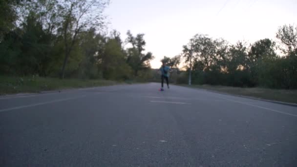 Carrera mixta hipster hombre longboarder carreras en el parque público de la ciudad en cámara lenta — Vídeo de stock