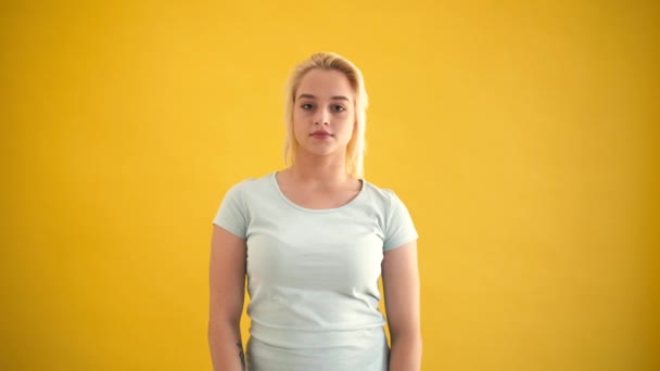 Счастливая блондинка белый плюс размер модели показывают большие пальцы вверх жеста на желтом фоне — стоковое видео
