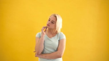 Genç sarışın beyaz artı boyutu model sarı arka plan ağır çekim bir fikrim var.