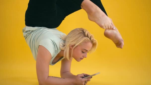 Caucasian model size plus practice yoga and text message at yellow background — Stock Video