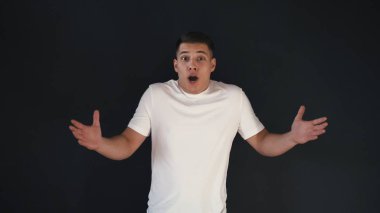 Genç adam beyaz gömlekli elleri ve inanılmaz sözcükler wow çığlık atmaya yıldız kaldırıyor. Hayran olduğunu. Üzerinde siyah backgorund izole