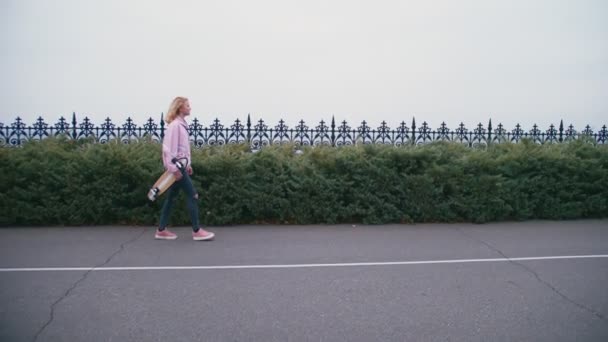 Docela krásné světlé bokovky žena s skateboard longboard — Stock video