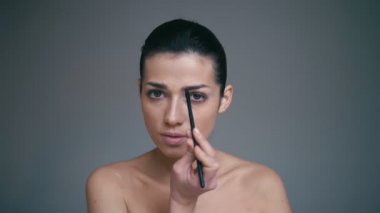 Güzellik kavramı. Makyaj koyarak kadın. Fırça ile boyama kaşları