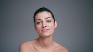 Parlak gözlü güzel gülümseyen mutlu esmer kadın portresi. Ağır çekim cilt bakım kavramı