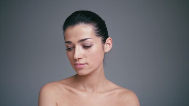 Красота портрет здорового женского лица с натуральной кожей изолированы на сером фоне. Концепция косметологии — стоковое видео