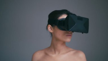Sanal gerçeklik Vr gözlüklü genç kadın. Gri arka plan üzerinde izole. Geleceğin teknolojisi kavramı