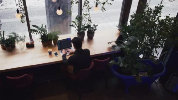 Ovanifrån av blandad ras man arbetar med laptop och smart phone Café — Stockvideo