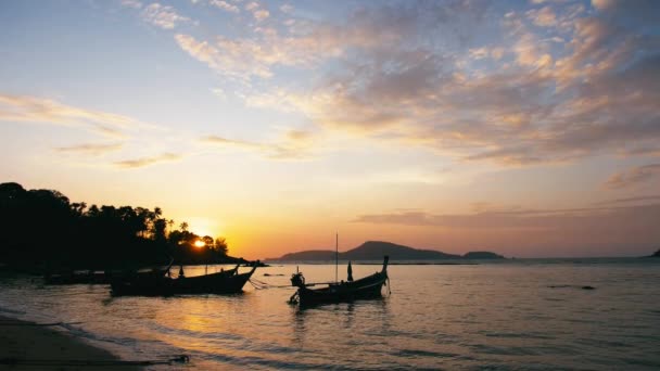 Длиннохвостые рыбацкие лодки на пляже Раваи на Пхукете Таиланд на восходе солнца — стоковое видео