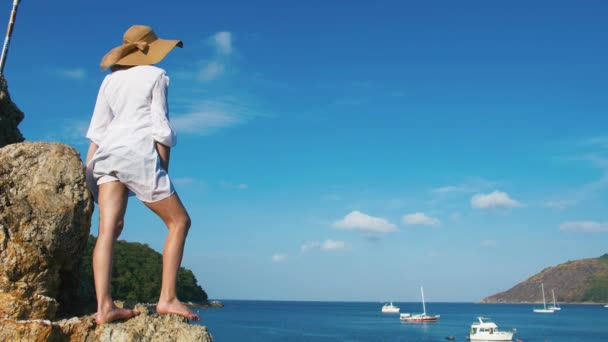 Osamělá dívka v klobouku kráčí podél pobřeží ostrova. Tropický ráj pláž při západu slunce — Stock video