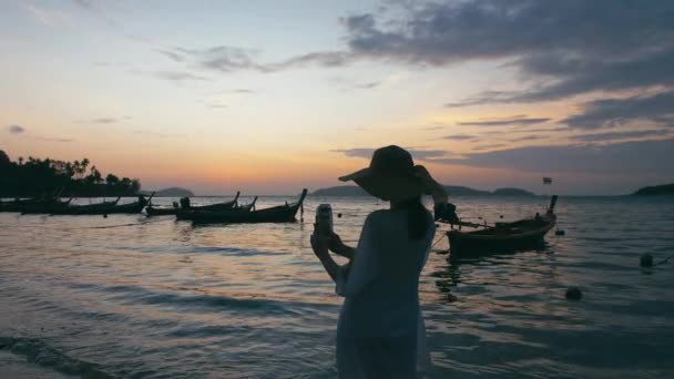 Beautiful woman taking photos with smart phone technology on paradise beach — Stock Video