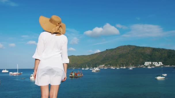 Une fille solitaire en chapeau marche le long de la côte de l'île. Plage paradisiaque tropicale au lever du soleil — Video