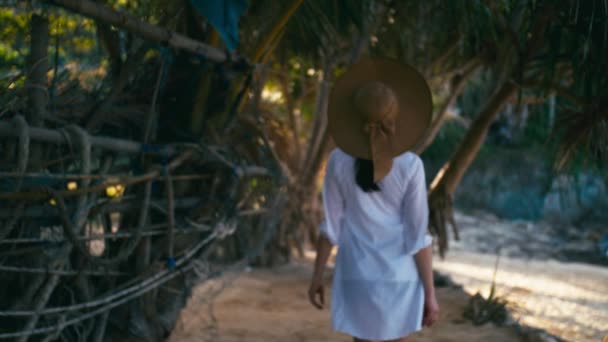 Una ragazza sola con il cappello sta camminando lungo la costa dell'isola. Spiaggia tropicale paradisiaca all'alba — Video Stock