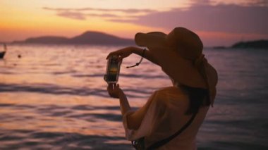 Cennet plaj üzerinde akıllı telefon teknolojisi ile fotoğraf çekmek güzel kadın