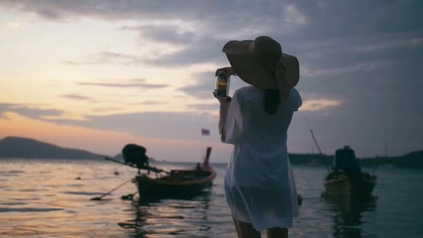 Красивая женщина фотографирует с помощью смартфонов на райском пляже — стоковое видео