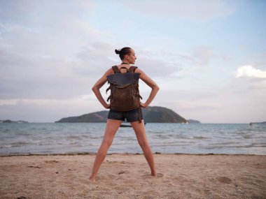 Tıbbi Anti-smog maskesi giymiş bir deniz manzaranın sırt çantası ile kadın gezgin