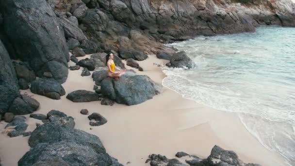 Mujer caucásica en traje amarillo practicando yoga ejercicio de fitness en la orilla del mar — Vídeo de stock