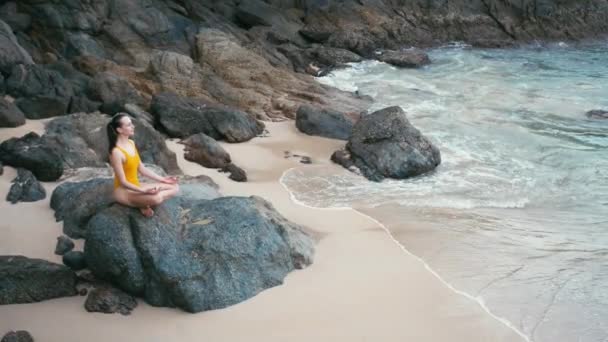 Kaukasische Frau im gelben Smiwsuit praktiziert Yoga-Fitness-Übung am Strand — Stockvideo
