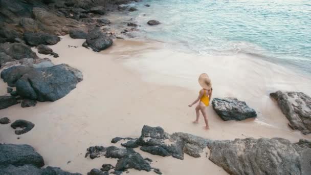 黄色の水着は美しい熱帯の白い砂浜のビーチに徒歩で 若い女性の背面します 海辺での休暇 — ストック動画